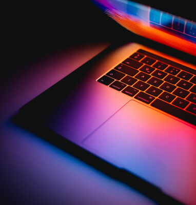 Laptop mit leuchtendem Bildschirm im Dunklen